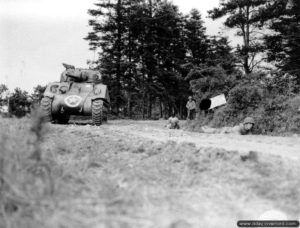 10 juillet 1944 : des soldats de la 90ème division d’infanterie américaine, appuyés par un char Sherman, sont à couvert dans le secteur de Saint-Jores. Photo : US National Archives