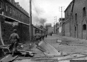 9 août 1944 : une colonne de soldats américains de la 83ème division d’infanterie progresse dans Saint-Malo encore en proie aux flammes. Photo : US National Archives