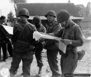 Le Major General Manton Sprague Eddy commandant la 9th Infantry Division étudie une carte de la région de Beauvain avec son aide de camp. Photo : US National Archives