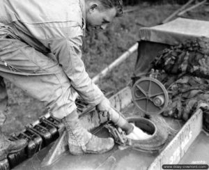 Un sapeur fait le plein de carburant de la cuve d’un GMC CCKW 353 utilisé en camion-citerne à Port-en-Bessin. Photo : US National Archives