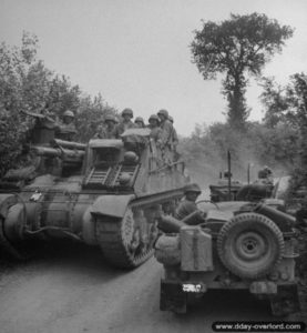 Deux véhicules Jeep croisent un canon automoteur M-7 Priest dans le secteur de Saint-Georges-d’Elle. Photo : US National Archives