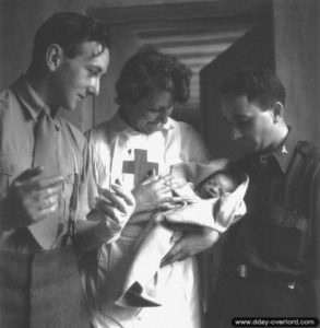Deux infirmiers canadiens et une infirmière de la Croix Rouge quelques minutes après la naissance de la petite Marie-France à Villons-les-Buissons. Photo : US National Archives