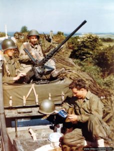 The crew of a half-track M3 is waiting for boarding in England while reading the guide on France and the French. Photo: US National Archives