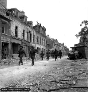 10 juillet 1944 : une colonne de soldats canadiens progresse rue du général Moulin à La Maladrerie. Photo : US National Archives