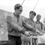Photos of Port-en-Bessin in 1944 5 Ouverture d’une vanne du pipeline de Port-en-Bessin pour les deux militaires américains et le militaire britannique (au centre), dans le cadre de l'opération PLUTO permettant le ravitaillement des armées en carburant ("minor system"). Photo : US National Archives