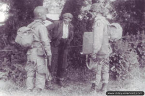 Deux parachutistes américains de la 101st Airborne Division cherchent des renseignements auprès d’un civil normand dans le secteur de La Barquette à Sainte-Côme-du-Mont. Photo : US National Archives