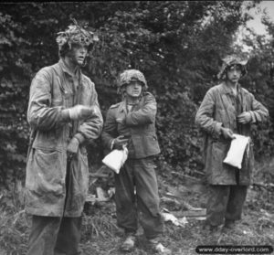 Des prisonniers allemands, épuisés, se déséquipent sur ordre de soldats américains près de Saint-Georges-d’Elle. Photo : US National Archives