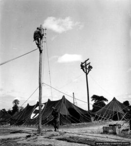 28 juillet 1944 : installation de lignes électriques par des sapeurs américains au profit de l’hôpital de campagne de Saint-Hilaire-Petitville. Photo : US National Archives