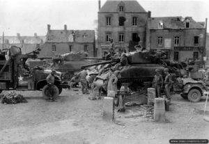 26 juillet 1944 : deux chars Sherman M4A1 et un Sherman M4 appartenant au 32nd Armored Regiment de la 3rd (US) Armored Division ainsi que des véhicules de transport dans le centre-ville de Saint-Jean-de-Daye. Photo : US National Archives
