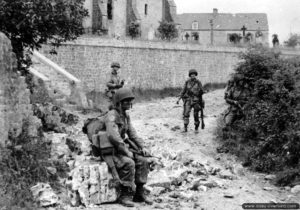 Un stick commandé par le capitaine Kenneth Johnson de la HQ Company du 508th Parachute Infantry Regiment, 82nd Airborne Division progresse aux abords du cimetière de Saint-Marcouf le 6 juin 1944. Photo : US National Archives