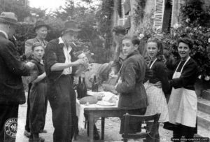 7 juin 1944 : une famille française de Sainte-Mère-Eglise accueille deux parachutistes de la 82ème division aéroportée. Photo : US National Archives