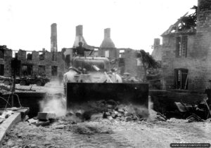 Un char M4A1 Sherman équipé d’une lame de bouteur déblaie les gravats le long de la rue du Centre à Lonlay-l’Abbaye. Photo : US National Archives