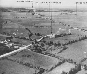 Vue aérienne prise au sud-ouest de Saint-Côme-du-Mont en direction du nord-est. Les repères indiquent les ponts sur les marais en direction de Carentan. Photo : US National Archives