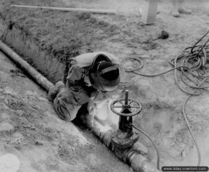 28 juillet 1944 : mise en place de tuyaux d’alimentation en eau au profit de l’hôpital de campagne de Saint-Hilaire-Petitville. Photo : US National Archives