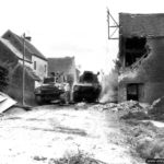 19 août 1944 : un char M4 Sherman dépasse un autre char Sherman V détruit appartenant à l’escadron C du 29th Reconnaissance Regiment (The South Alberta Regiment) de la 4th Canadian Armoured Division à Saint-Lambert-sur-Dive. Photo : IWM