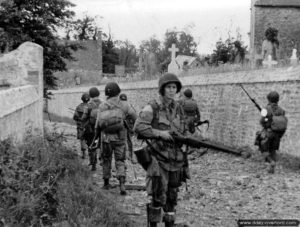 Un stick commandé par le capitaine Kenneth Johnson de la HQ Company du 508th Parachute Infantry Regiment, 82nd Airborne Division progresse aux abords du cimetière de Saint-Marcouf le 6 juin 1944. Photo : US National Archives