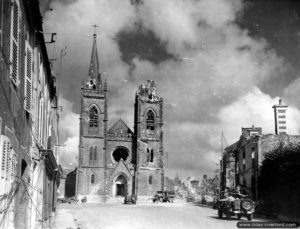 20 juillet 1944 : des véhicules américains traversent la place de l’Eglise à La-Haye-du-Puits. Photo : US National Archives