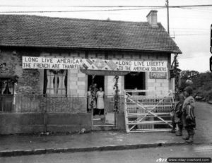 4 juillet 1944 : la maison de l’électricien M. Victoire décorée pour fêter la libération, rue de Balleroy au Molay-Littry. Photo : US National Archives