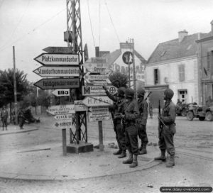 Des soldats américains appartenant à la 83ème division d’infanterie observent les panneaux de signalisation allemands à Saint-Malo. Photo : US National Archives