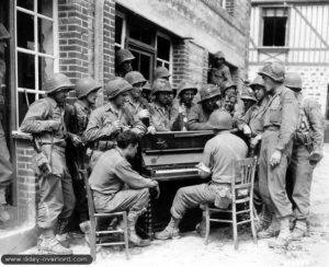 Moment de détente pour ces soldats américains de la 2nd Heavy Armored Division autour d’un piano sorti des décombres. Photo : US National Archives