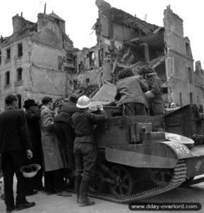 11 juillet 194 : des soldats canadiens à bord d’un Universal Bren Carrier donnent de la nourriture à la population de Caen. Photo : US National Archives