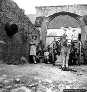 Deux soldats de la 11th Field Company partagent du lait avec des habitants de Creully devant leur ferme. Photo : Archives Canada