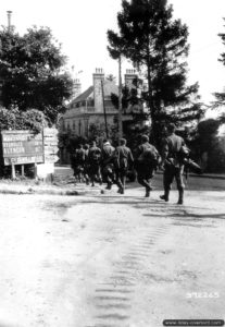 Des prisonniers allemands appartenant à la 708ème division d’infanterie sont escortés dans les rues de Domfront. Photo : US National Archives