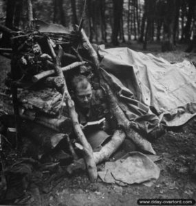 Un soldat américain de la 2nd (US) Infantry Division installé dans sa position individuelle composée de rondins de bois près de Saint-Georges-d’Elle. Photo : US National Archives