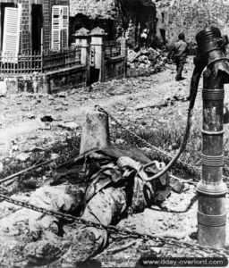 Le corps d’un soldat américain, tué par un engin explosif improvisé caché dans la fontaine de Saint-Marcouf. Photo : US National Archives