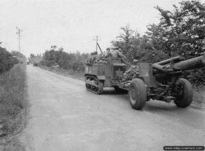 Un obusier M1 de 155 mm tracté par un tracteur chenillé M5 sur la RN 13 dans le secteur de Sainte-Mère-Eglise. Photo : US National Archives