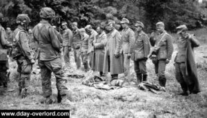 Des prisonniers allemands sont inspectés par des paras du 502nd PIR près de Saint-Martin-de-Varreville. Photo : US National Archives