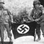 Forrest Guth (droite) et Francis Mellet (gauche) au même endroit à la ferme Marmion de Ravenoville. Photo : US National Archives