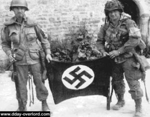 Forrest Guth (droite) et Francis Mellet (gauche) au même endroit à la ferme Marmion de Ravenoville. Photo : US National Archives