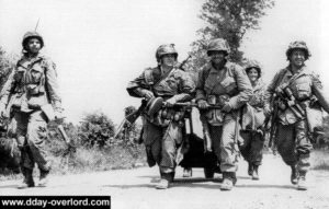 Des paras du 506th PIR tirant une remorque M3A4 en route vers Carentan. Photo : US National Archives