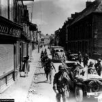 Des éléments de la 326th Airborne Medical Company dans la rue Holgate à Carentan. Photo : US National Archives