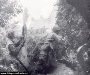 Des paras aux abords de la ferme Marmion à Ravenoville veulent déclencher le tir d'un tireur isolé. Photo : US National Archives