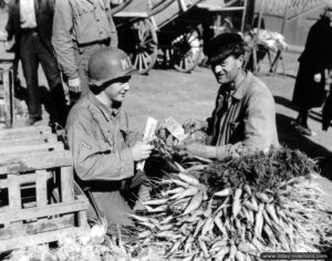 7 juillet 1944 : le première classe Luddie Rachal de la police militaire fait son marché à Cherbourg. Photo : US National Archives