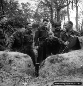 15 juillet 1944 : brieffing entre officiers du Cameron Highlanders of Ottawa. De gauche à droite le capitaine R. F. Ferrier, le lieutenant J. A. Morris, le Major J. W. Forth, le MajorRoger Rowley, le capitaine J. M. Lambert, le capitaine G. A. Harris et le lieutenant-colonel P. C. Klaehn. Photo : US National Archives