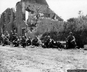 7 juillet 1944 : des éléments du Génie se sont arrêtés à proximité d’une maison en ruines à La-Haye-du-Puits. Photo : US National Archives