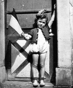 4 juillet 1944 : un jeune enfant du Molay-Littry agite un drapeau français pour célébrer la libération. Photo : US National Archives