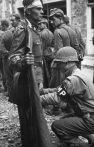 27 juillet 1944 : le SS-Untersturmführer Kurt Peters du III.Battalion SS-Pz.Gren.Rgt. 37, 17.SS-Pz.Gren.Div. « Götz von Berlichingen » est fouillé par le lieutenant Paul Unger, 2nd (US) Armoured Division à Roncey. Photo : US National Archives