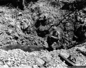Un civil américain du War Department sous uniforme analyse les fondations du réseau ferroviaire du centre de montage et de ravitaillement de V1 à La Tuilerie à Yvetot-Bocage. Photo : US National Archives