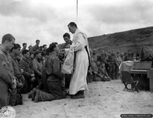 12 juin 1944 : messe au cimetière provisoire N°1 à Saint-Laurent-sur-Mer célébrée par le révérend William Dempsey sur la plage de Vierville-sur-Mer. Photo : US National Archives