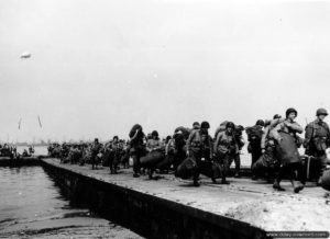 Personnels militaires utilisant un ponton du Mulberry A. Photo : US National Archives