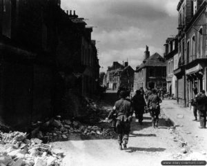 Des Américains progressent dans la rue Holgate de Carentan. Photo : US National Archives