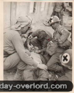 26 juillet 1944 : des infirmiers prennent en compte des soldats blessés par l’explosion d’une mine à Coutances. Photo : US National Archives