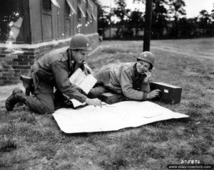 6 septembre 1944 : deux capitaines consultent une carte à côté d’un téléphone de campagne à Valognes. Photo : US National Archives