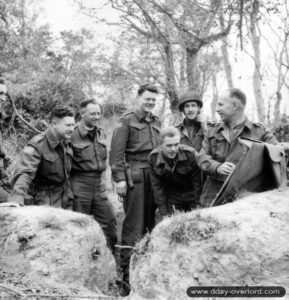 15 juillet 1944 : brieffing entre officiers du Cameron Highlanders of Ottawa. De gauche à droite le capitaine R. F. Ferrier, le lieutenant J. A. Morris, le Major J. W. Forth, le MajorRoger Rowley, le capitaine J. M. Lambert, le capitaine G. A. Harris et le lieutenant-colonel P. C. Klaehn. Photo : US National Archives