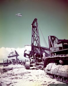 Des sapeurs canadiens équipés d'une grue et d'un bulldozer déblaient la plage. Photo : IWM