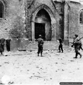 9 juillet 1944 : des prisonniers allemands sont rassemblés devant l’église de La-Haye-du-Puits par des soldats appartenant au 121ème régiment de la 8ème division d’infanterie américaine. Photo : US National Archives